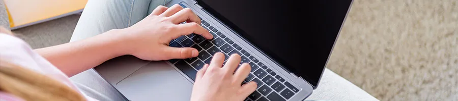 hand view of a person typing on a laptop