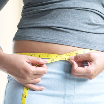 person using a measuring tape on his waist