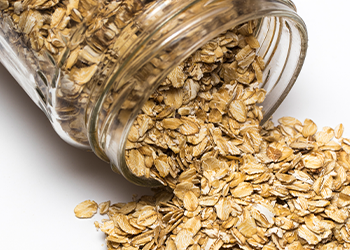 glass jar spilling out rolled oats