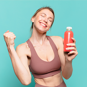 woman happy in gym clothes holding a drink