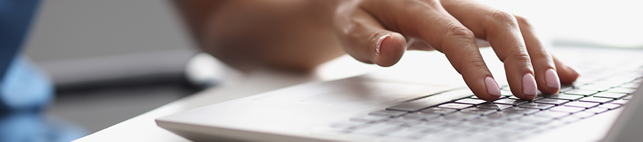 hand view of a person typing on a laptop