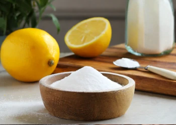 Citric acid powder with lemons on top of counter