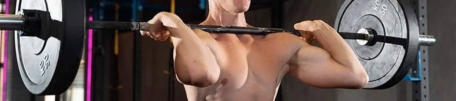 A man lifting a barbell in his shoulders