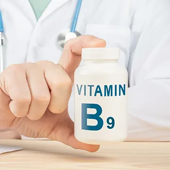 Vitamin B9 container being held by health professional