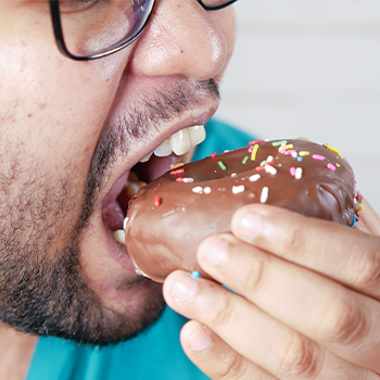 mouth view of a man eating a donut