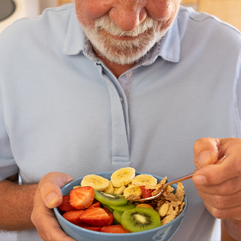 old man with bowl of fruits