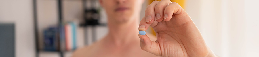 shirtless man holding up a supplement