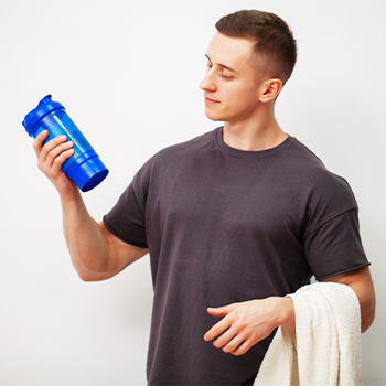 man looking at his workout tumbler