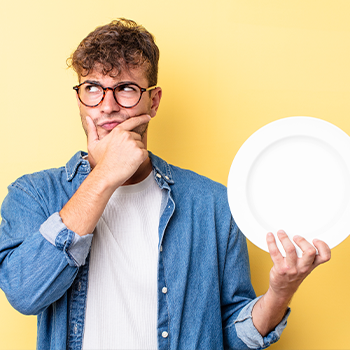 man holding up a plate and thinking
