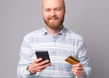 man holding up his phone and card
