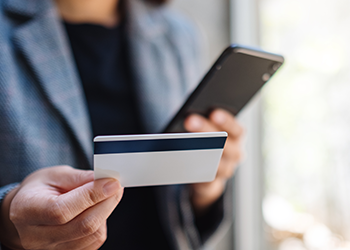 person using his phone and card