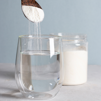 glass of water getting filled with white powder