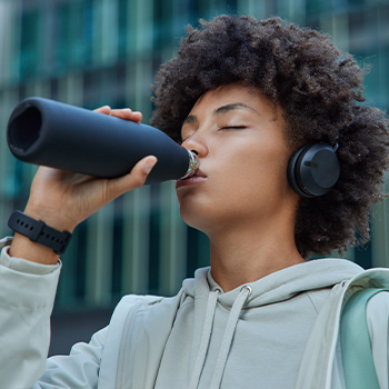 woman drinking from a tumbler