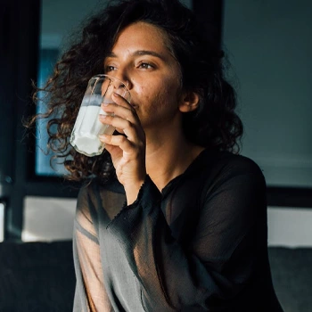 woman chugging a glass of milk