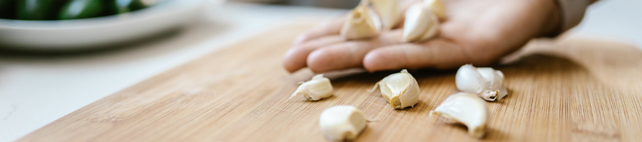 A man holding sliced garlic on a chopping board