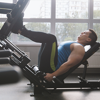man using a leg press machine in the gym