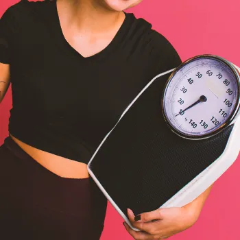 woman holding a weighing scale