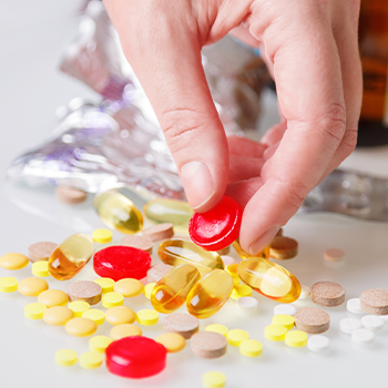 stack of vitamins getting picked by hands