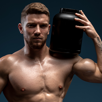 man holding up a protein powder container shirtless