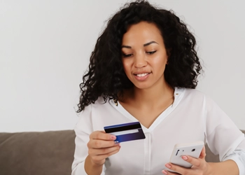 Woman ordering online using her card and smartphone