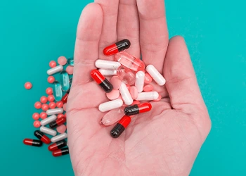 capsules and pills in a person's hands
