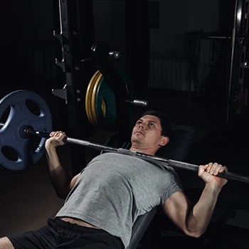 man using a barbell in a bench