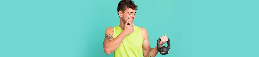 man looking at a kettlebell smiling