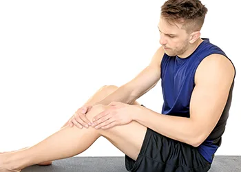 man looking at his knee in pain