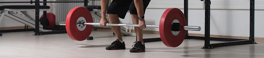 man lifting a red barbell