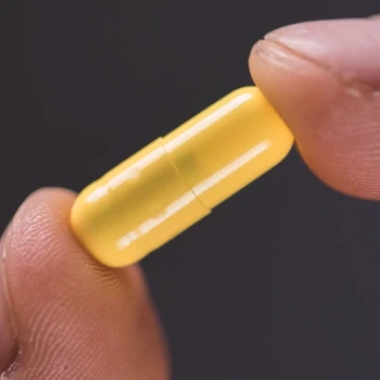 person holding a supplement pill