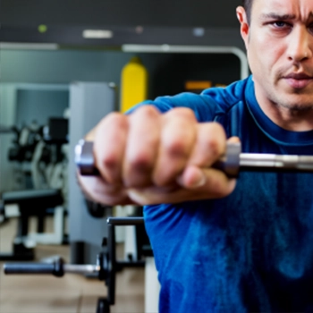 A man exercising in the gym wearing blue shirt