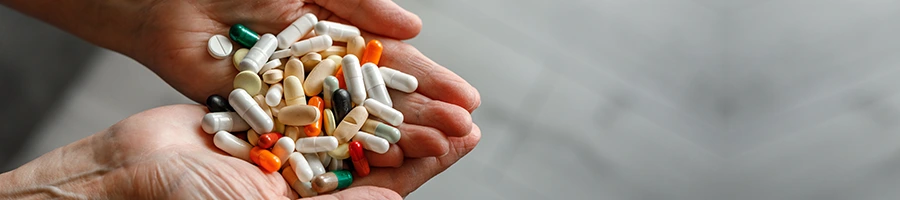 different capsules and pills in hands