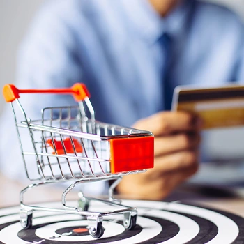 man using credit card and a mini shopping cart