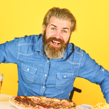A man at a table with pizza