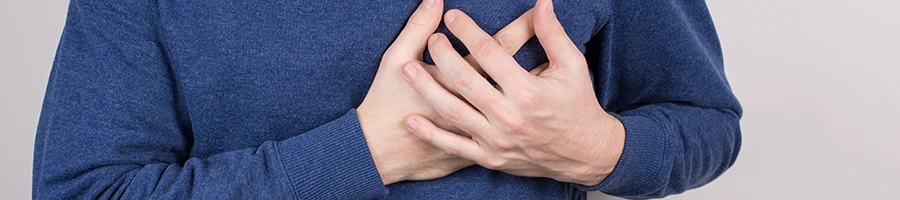 Man wearing sleeves holding his chest with both hands