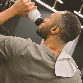 A man drinking pre-workout at the gym