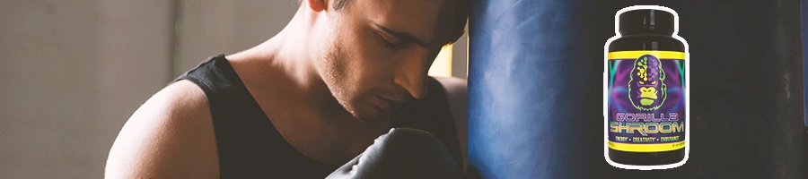 A man resting his head on a punching bag