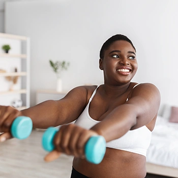 Black curvy woman doing exercise in her room