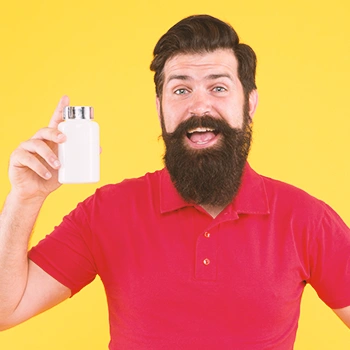 A smiling man holding a pill bottle