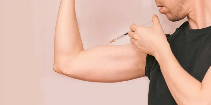 A man injecting a syringe on his arm