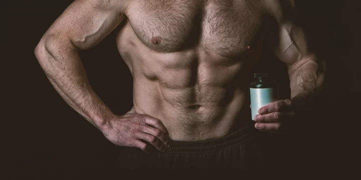 A muscular man holding a bottle