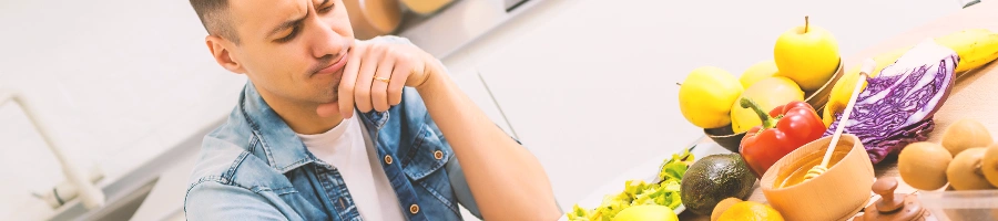 A man thinking while looking at vegetables