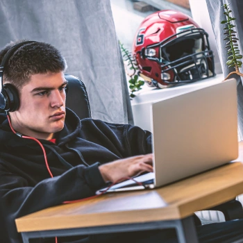 A man sitting down in front of his laptop