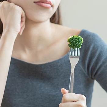 Holding a fork with green food