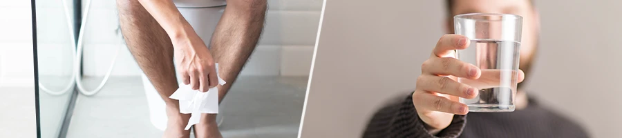 Inside a toilet room, man holding a glass of water