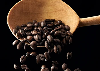 Pouring coffee beans using a spoon