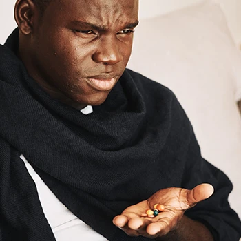 A serious man holding pills