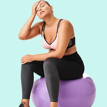 Exhausted woman resting on an inflatable purple ball