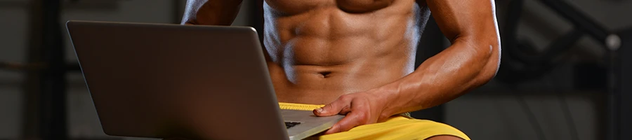 Muscular person using a laptop