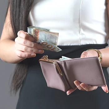 A close up shot of a woman checking money in her wallet